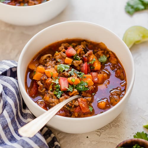 Chipotle turkey sweet potato chili served in a white bowl with a silver spoon