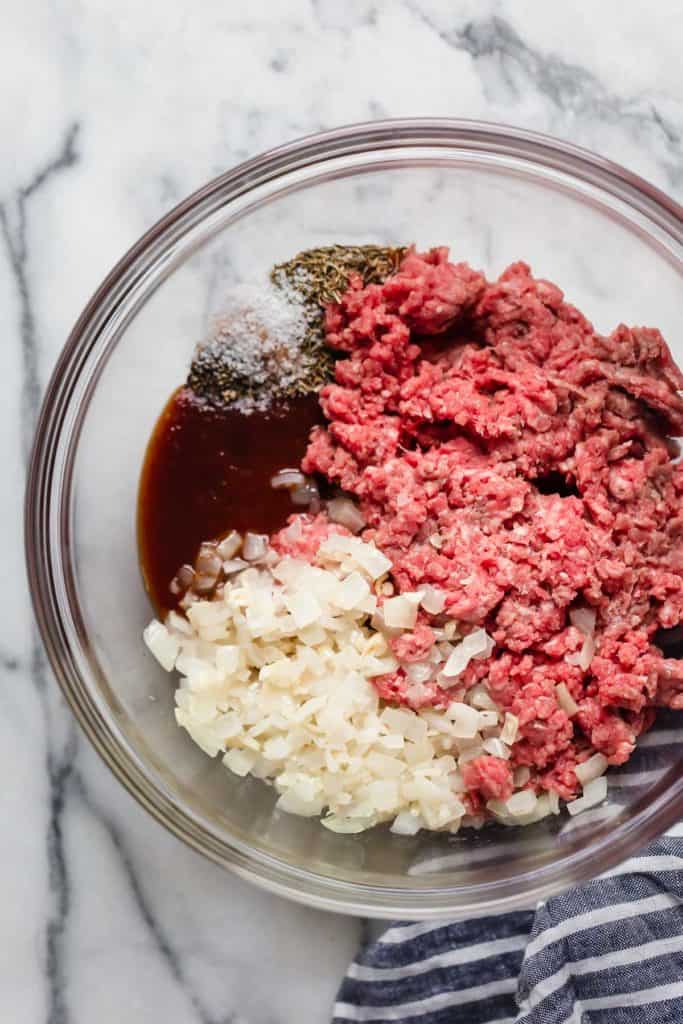 Overhead view of a glass bowl filled with BBQ Meatloaf Muffins ingredients