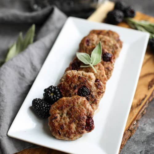 A rectangular plate filled with a row of Blackberry Sage Breakfast Sausages