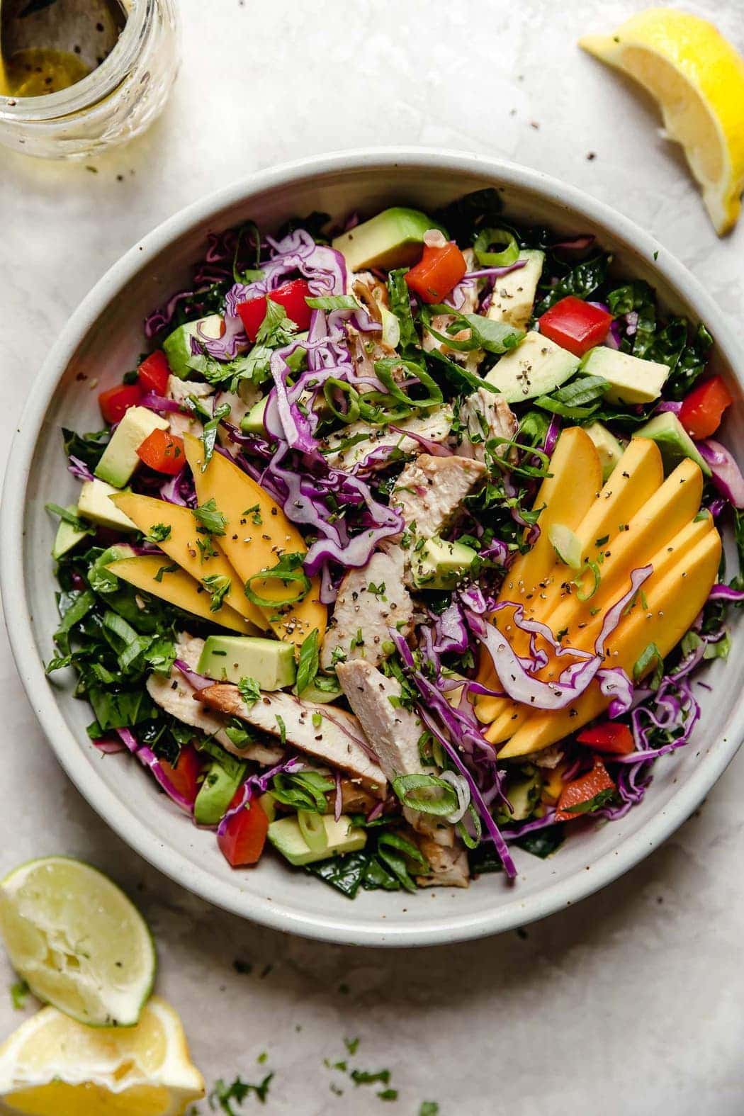 Mango Chicken Salad topped with seasoning and fresh herbs