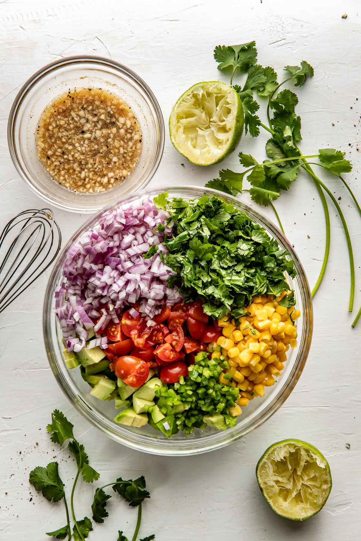 Overhead view of a bowl of Avocado Salsa ingredients ready for stirring. 