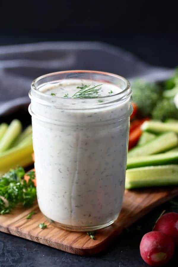 Paleo Ranch Dressing Dip in a mason jar surrounded by raw vegetables