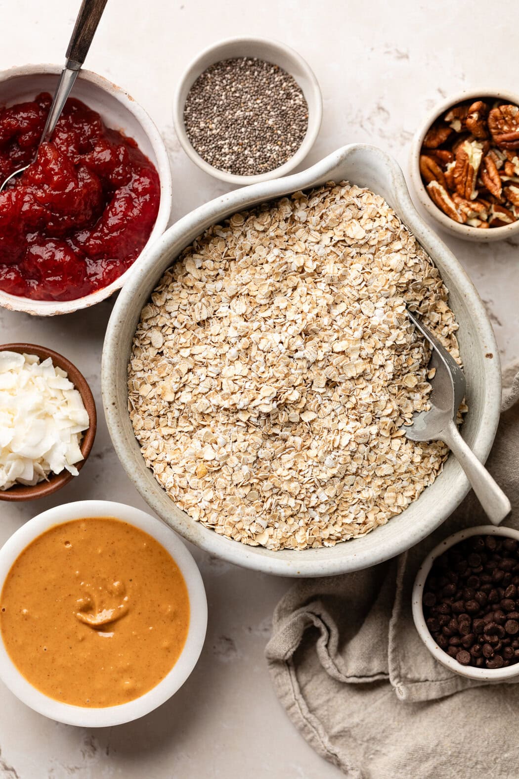 Overhead view of a variety of ingredients for No-Bake PB & J Bites in different sized bowls. 