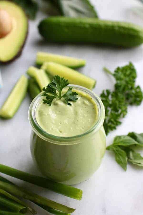 Green Goddess Dressing in a small glass jar topped with parsley