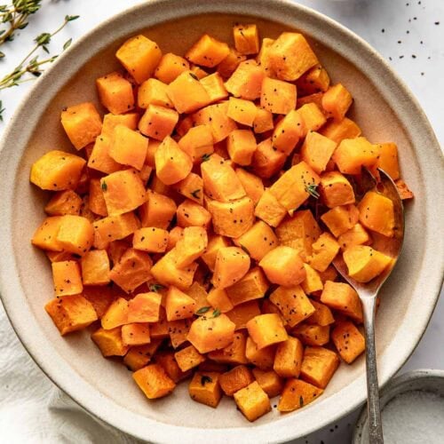Overhead view of a bowl of Roasted Butternut Squash cubes perfectly crisp and seasoned.