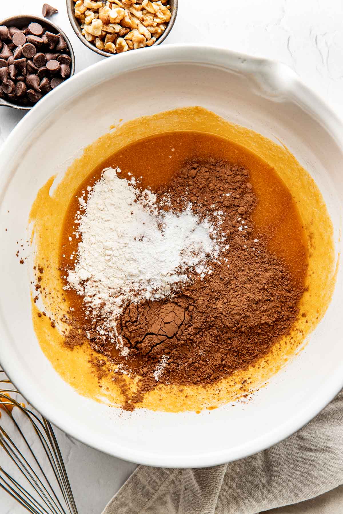 Overhead view of a white bowl filled with brownie ingredients ready for stirring. 
