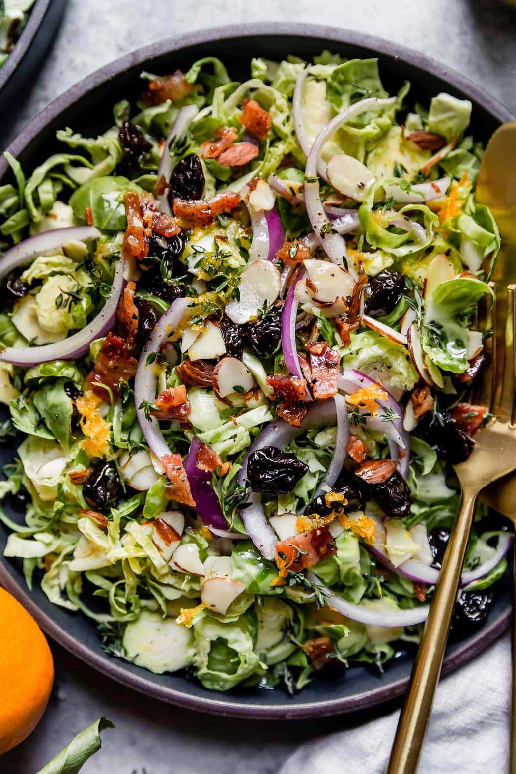 Overhead view of a black bowl of Brussels Sprouts Salad with Citrus Vinaigrette