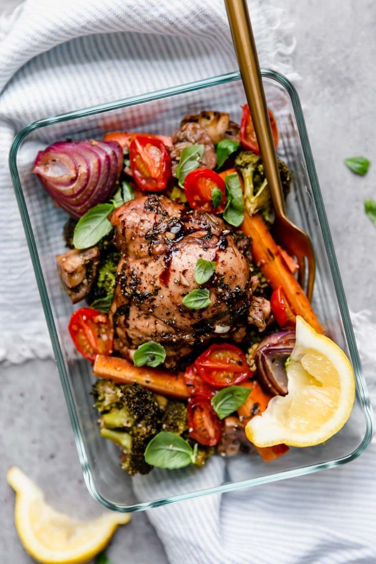 A glass container storing Sheet Pan Balsamic Chicken Veggie Bake for meal prep. 