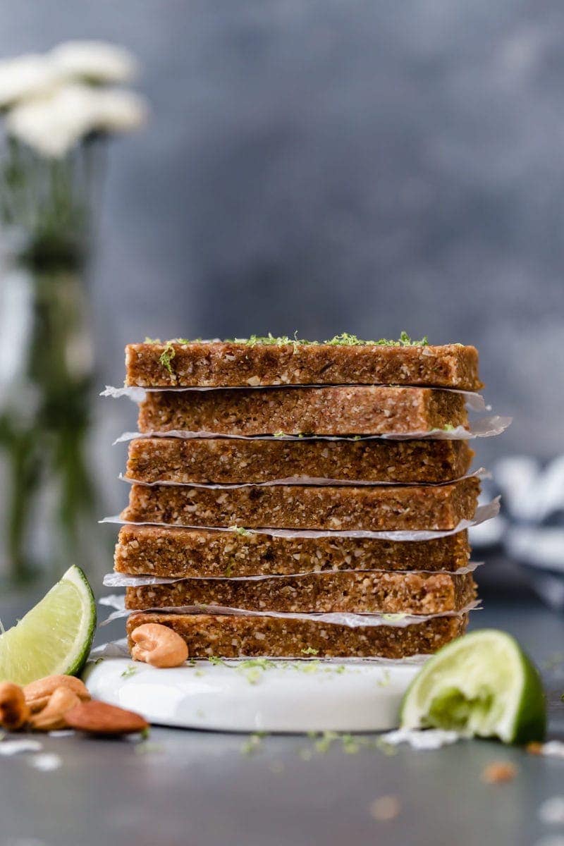 Seven Key Lime Energy Bars stacked on top of each other with parchment paper between each bar.