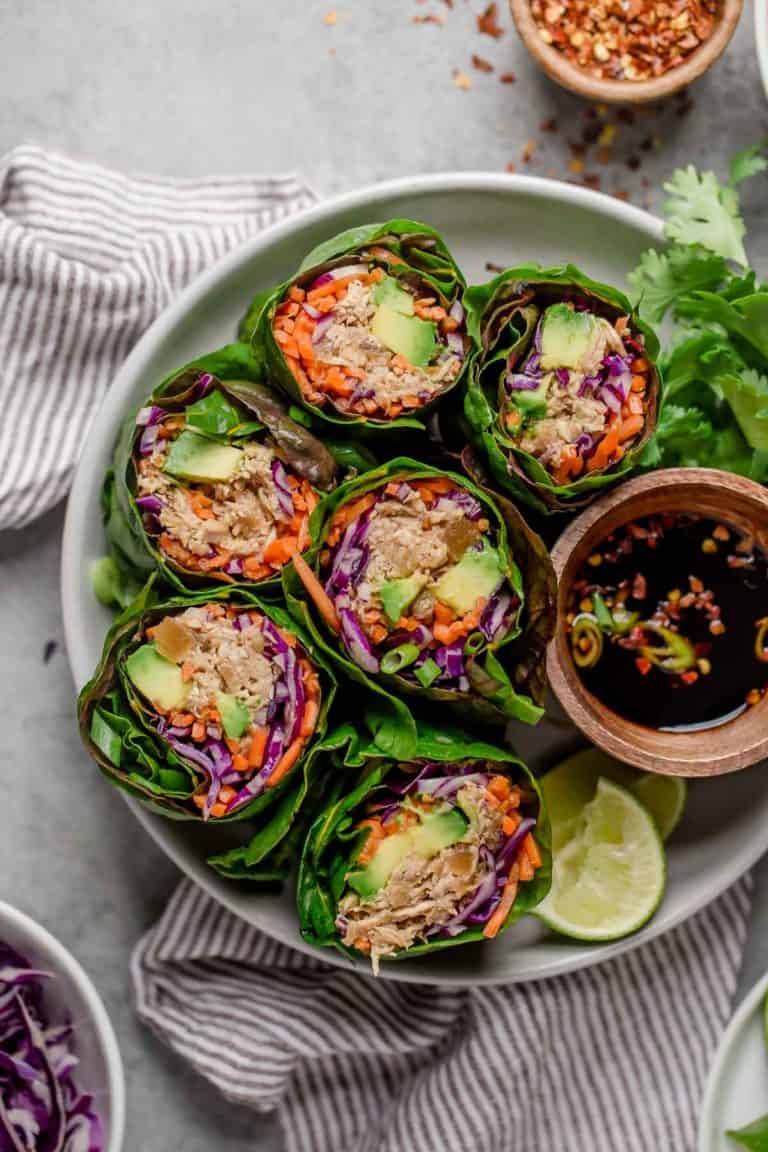 Slow Cooker Hawaiian Shredded Chicken wrapped in lettuce wraps served on white round tray with fresh lime wedges. 