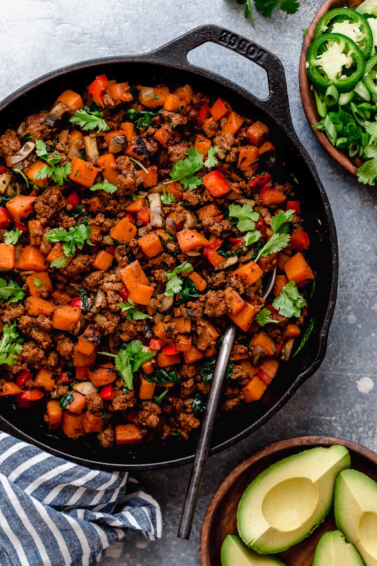 Tex-Mex Sweet Potato Hash in a black skillet with a spoon in it.