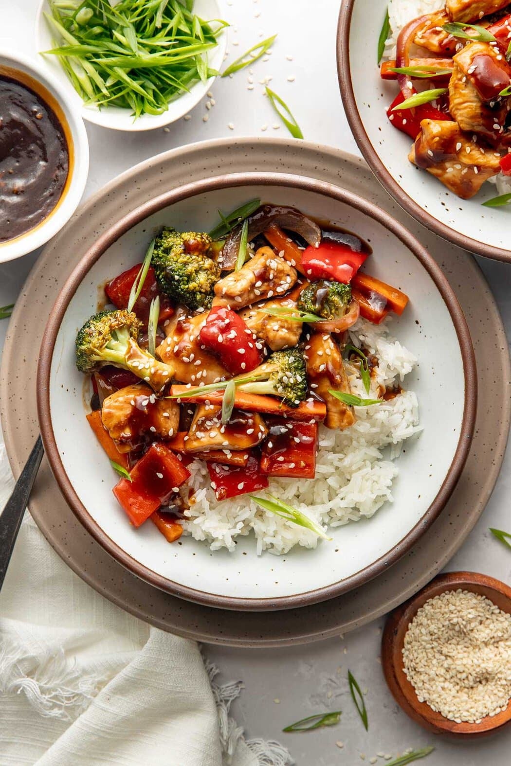 A bowl of sheet pan teriyaki chicken and vegetables over rice. 