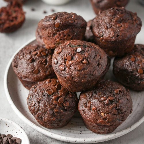 Serving platter piled high with chocolate zucchini muffins topped with chocolate chips