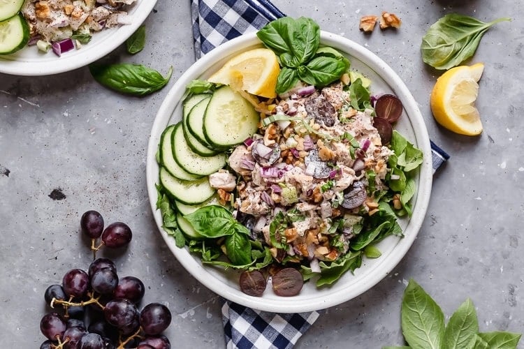 A full bowl of Chicken Waldorf Salad with fresh cucumbers and sliced grapes. 