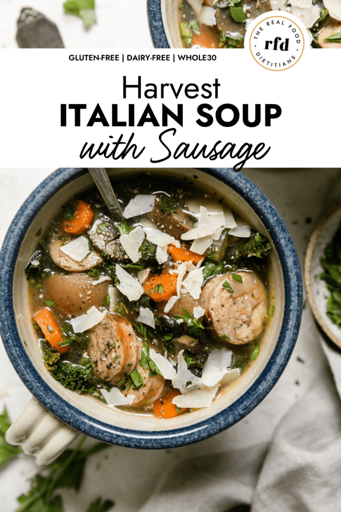 Overhead view bowl with handle filled with Harvest Italian Soup with Sausage, potatoes, and kale. Topped with shaved Parmesan.