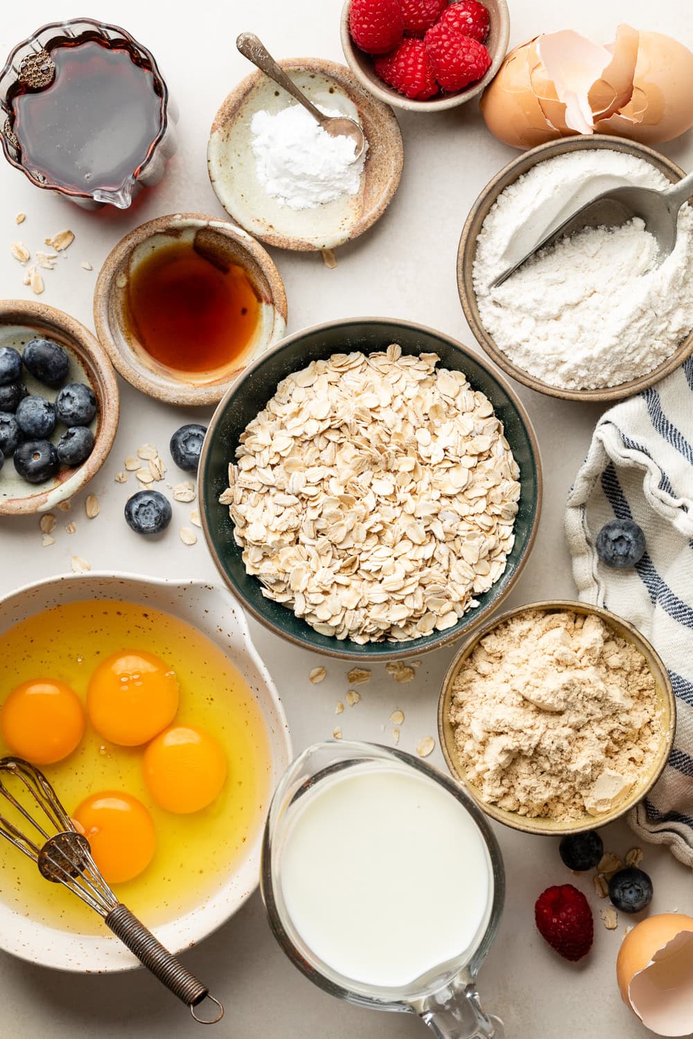 Overhead view of a variety of ingredients for Protein Waffles in different sized bowls. 
