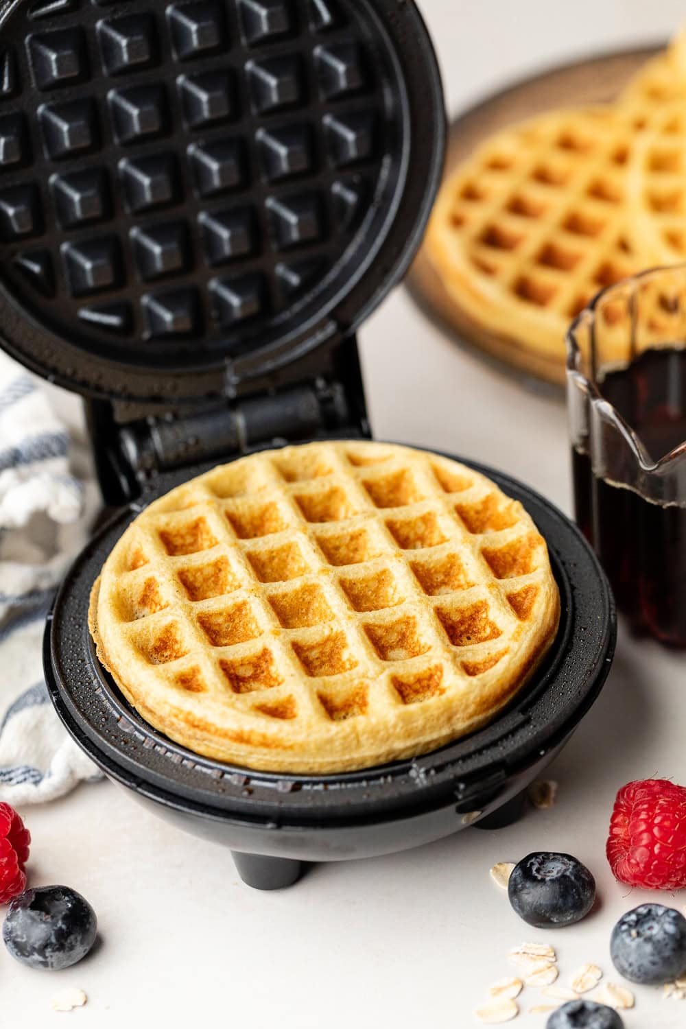 Close up view of a mini waffle iron filled with a freshly baked Protein Waffle. 