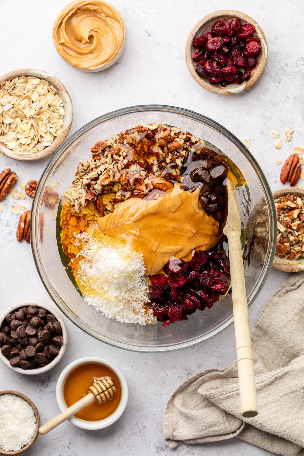 Overhead view of a glass bowl filled with Trail Mix Granola Bar ingredients ready for stirring. 