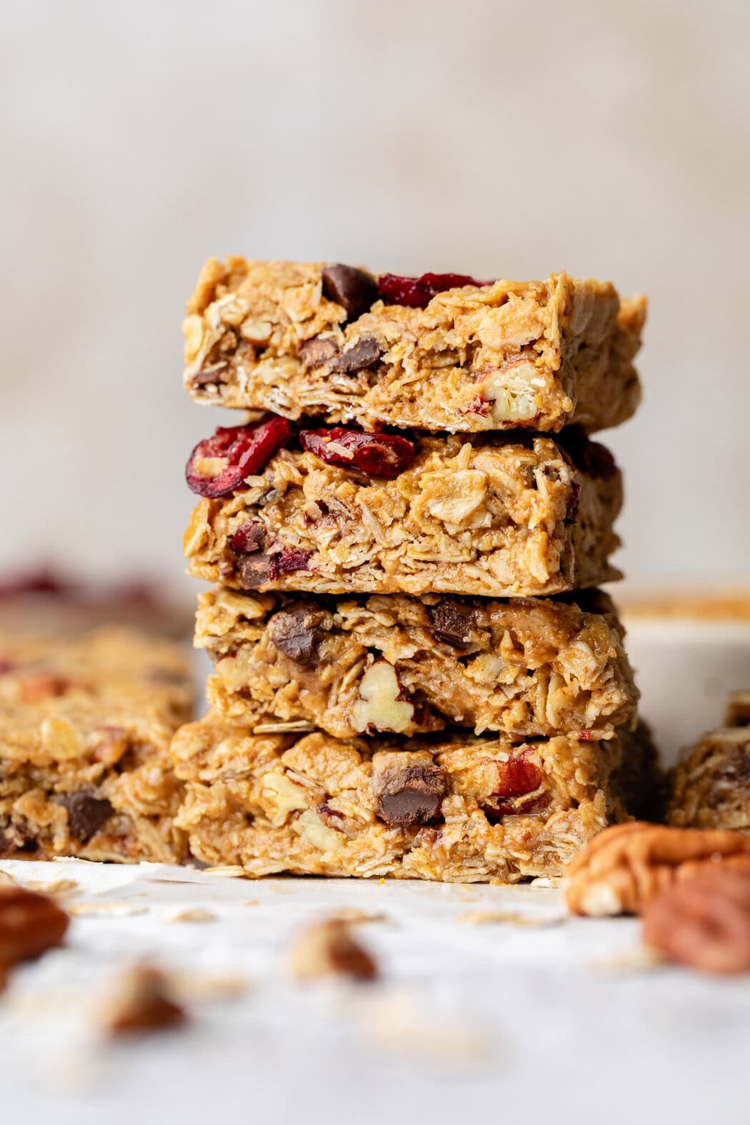 A close-up view of a stack of Trail Mix Granola Bars showing pecan pieces and dried cranberries. 