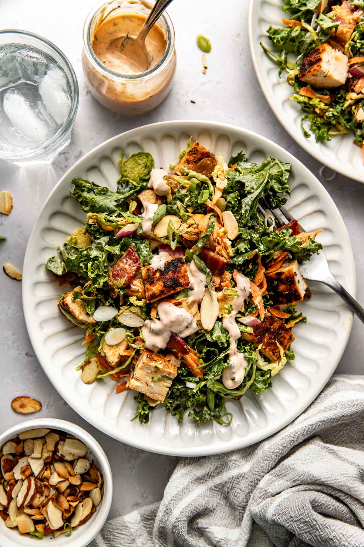 Overhead view of a colorful Chopped BBQ Ranch Chicken Salad topped with green onions and toasted sliced almonds.