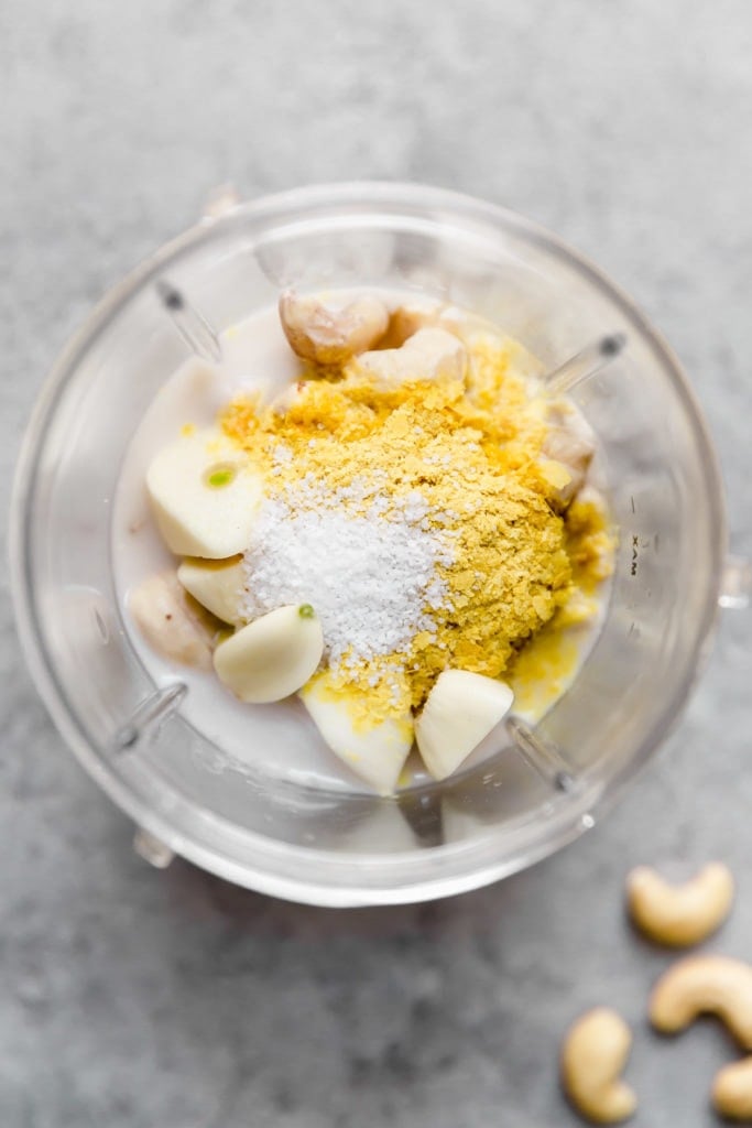 Overhead view of a blender cup filled with ingredients for a Creamy sauce