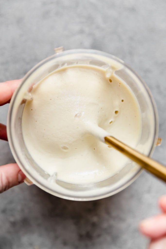 Overhead view of a blender cup filled with freshly blended creamy sauce for Creamy Chicken Spaghetti Squash with Bacon and Asparagus