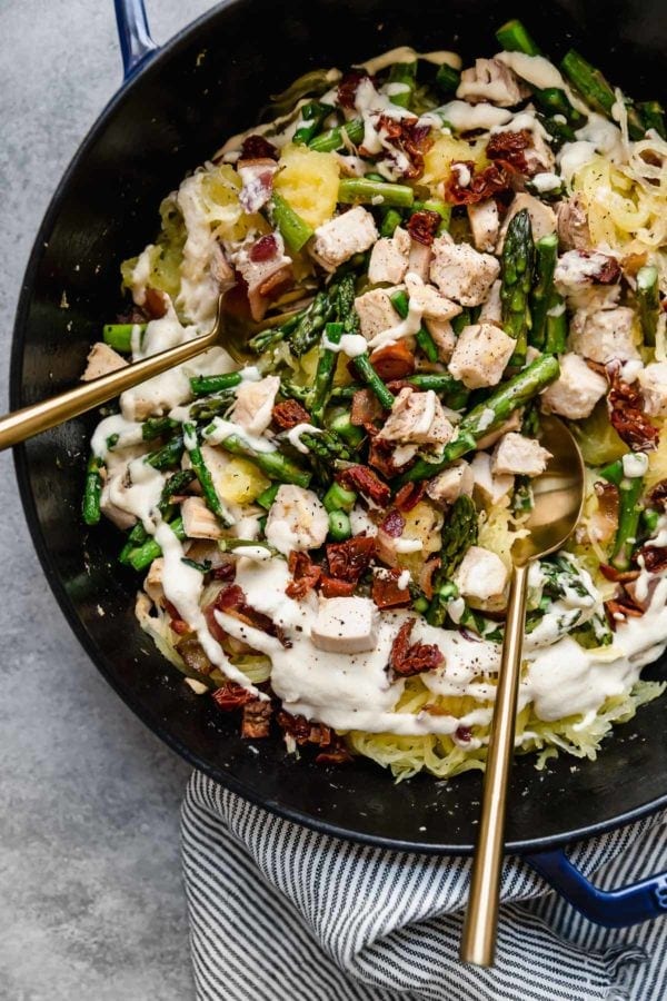 Overhead view of a skillet filled with Creamy Chicken Spaghetti Squash with Bacon and Asparagus