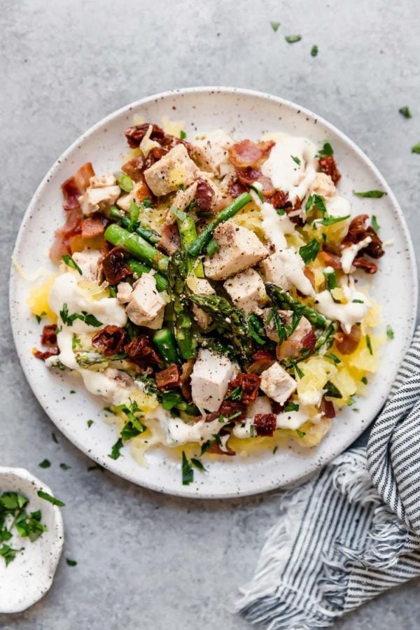 Overhead view of a plate of Creamy Chicken Spaghetti Squash with Bacon and Asparagus