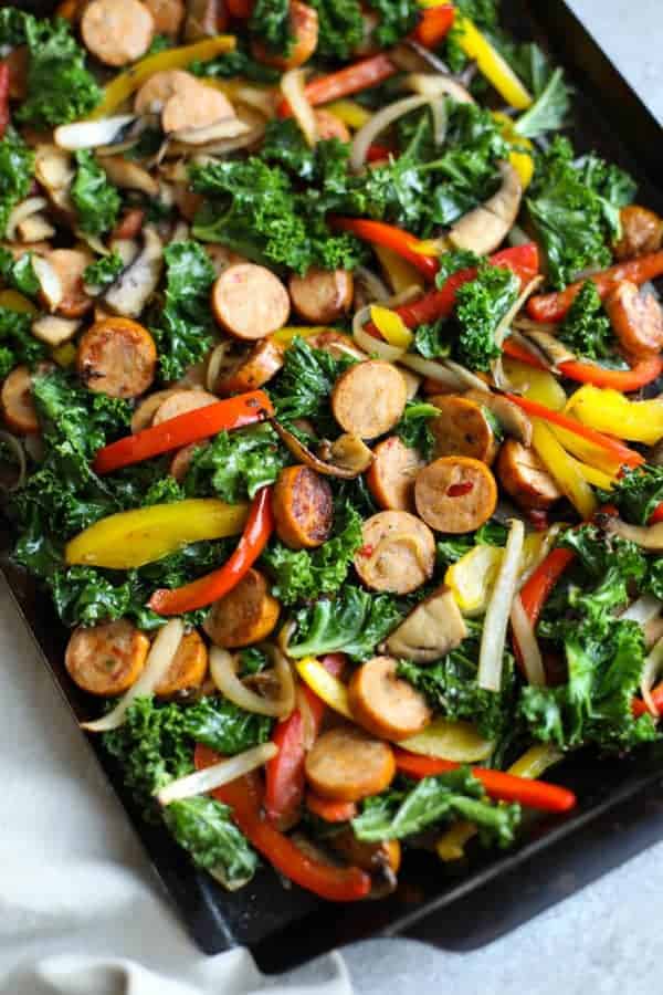 Grill plan with sliced sausages and veggies (kale, peppers, onions and mushrooms).