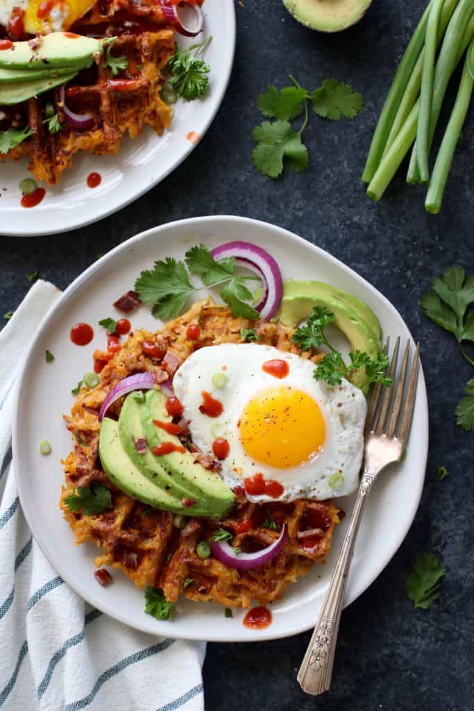Savory Sweet Potato Bacon Waffles topped with a fried egg and avocado slices
