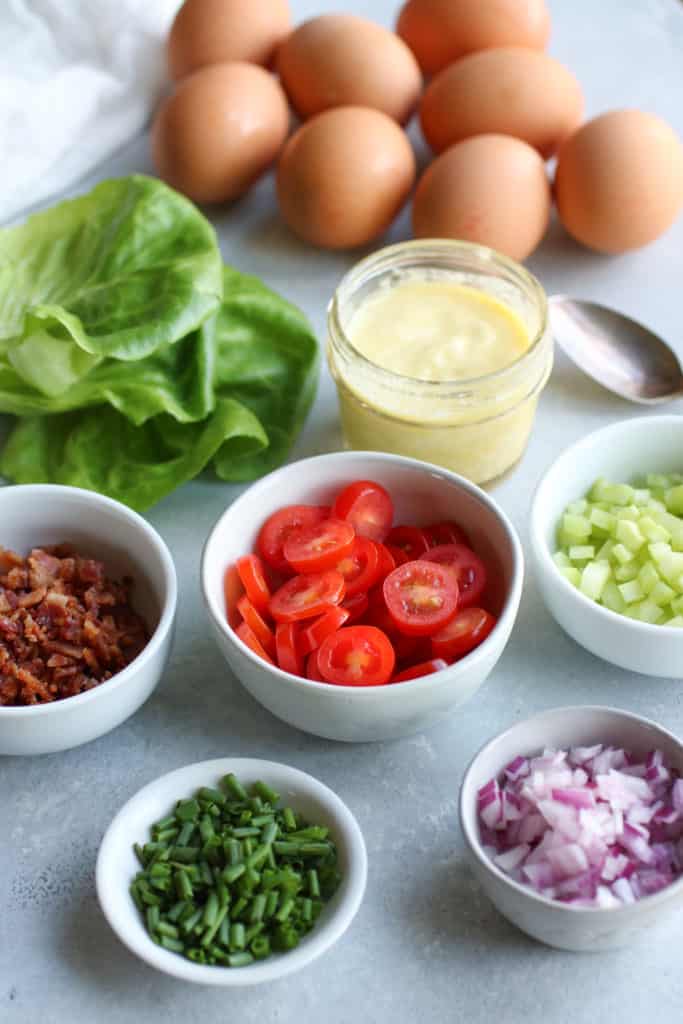 All ingredients for BLT egg salad lettuce wraps in small bowls.