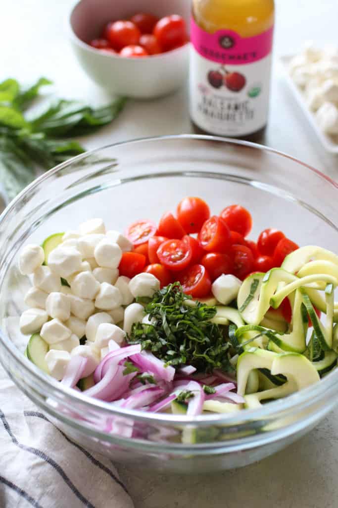 Caprese Zucchini Salad with Balsamic Vinaigrette ingredients in a glass bowl