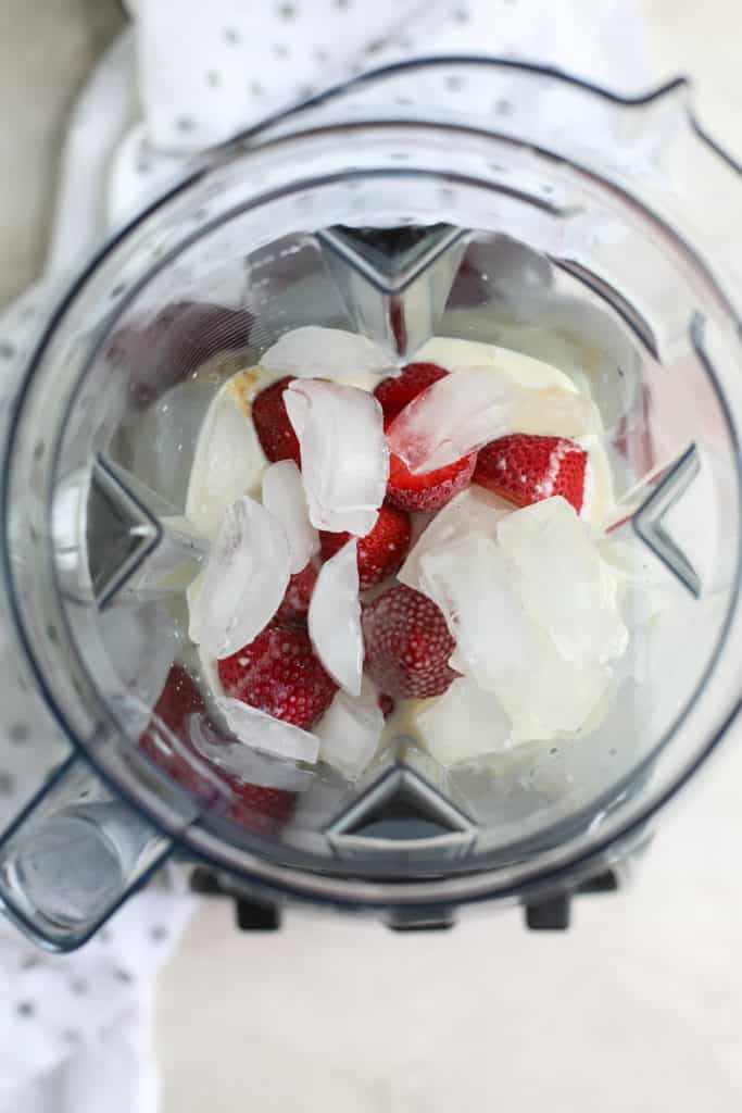 Strawberry Cheesecake Smoothie ingredients in a blender with ice
