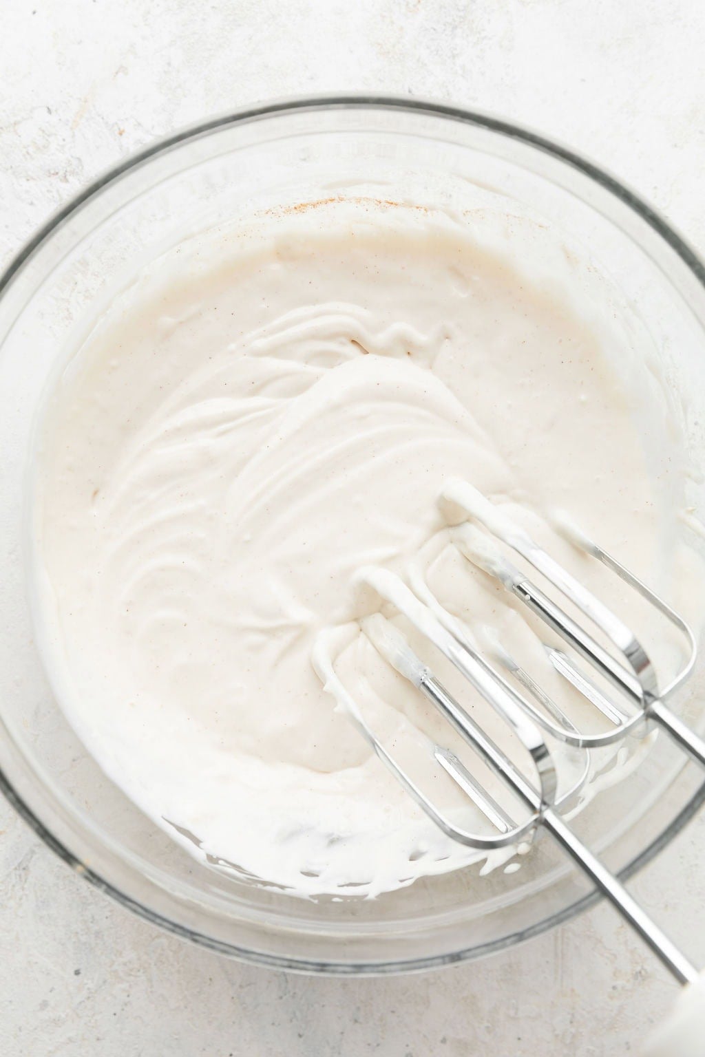 Overhead view of a glass bowl filled with freshly mixed fluffy fruit dip.