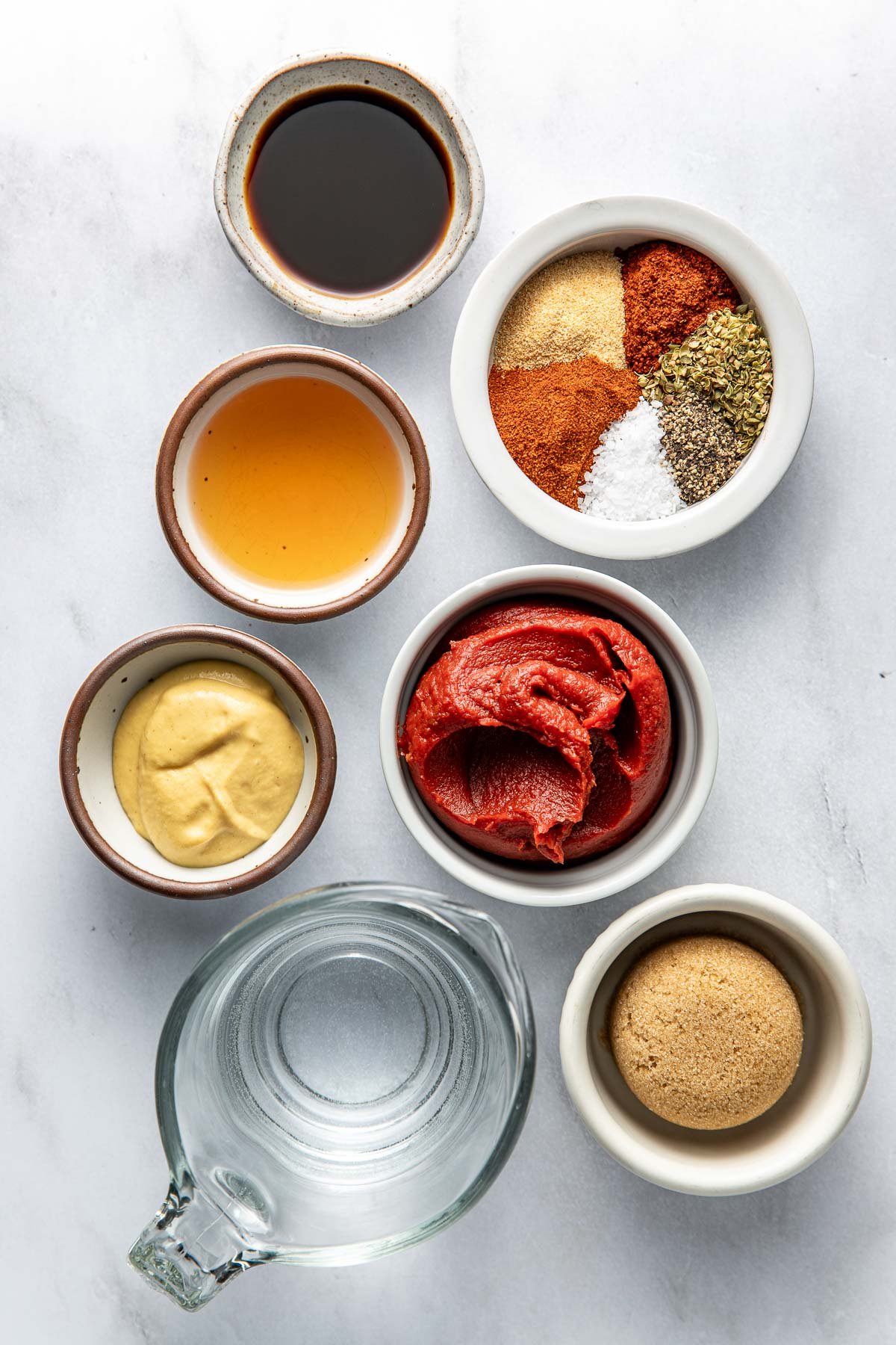 Overhead view of a variety of ingredients for Homemade BBQ Sauce in different sized bowls.