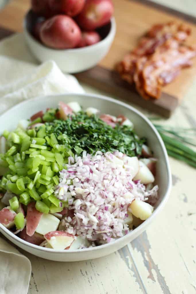 Overhead view of a bowl of Bacon Chive Potato Salad ingredients in a bowl