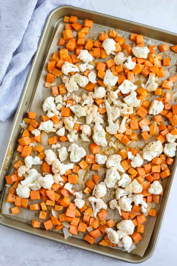 Sheet pan filled with diced sweet potatoes and cauliflower
