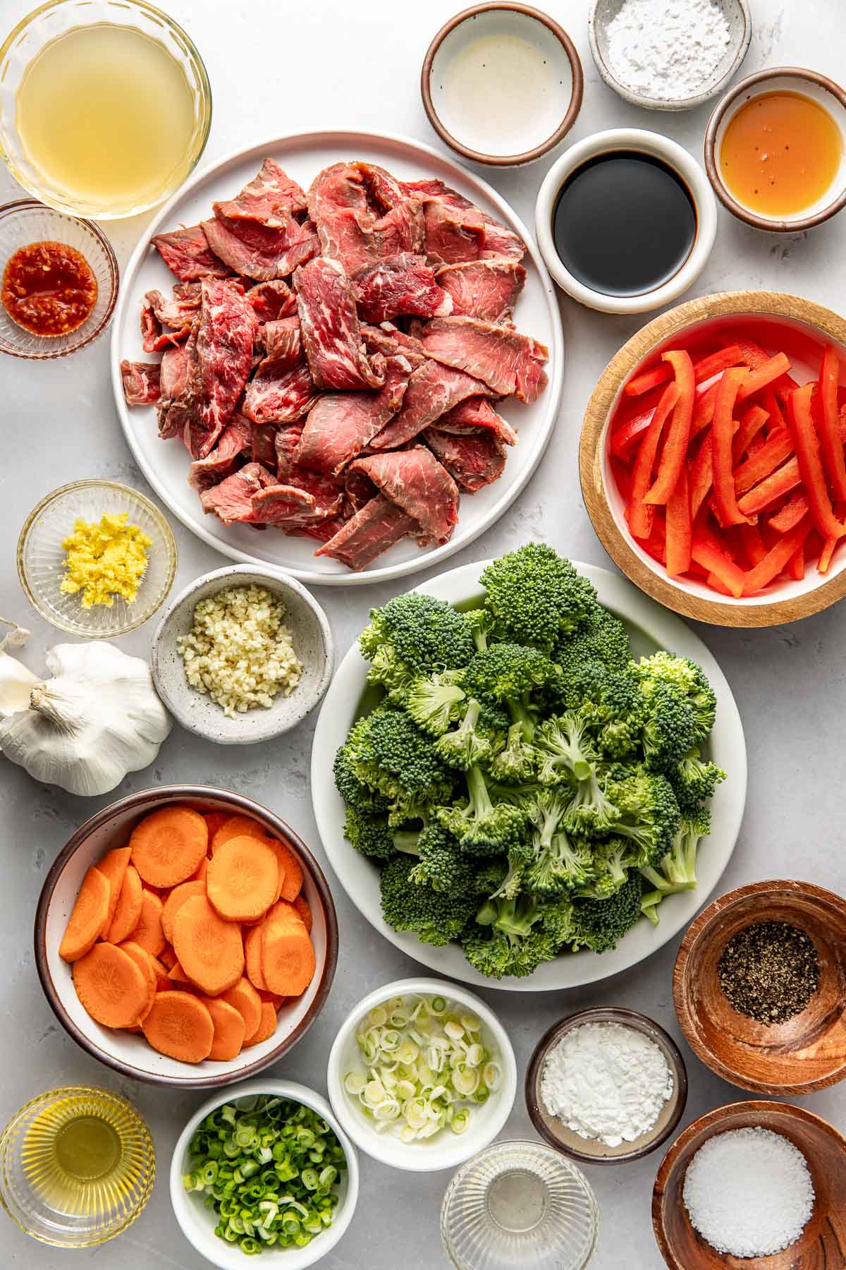 Overhead view of a variety of ingredients for Steak Stir Fry in different sized bowls.
