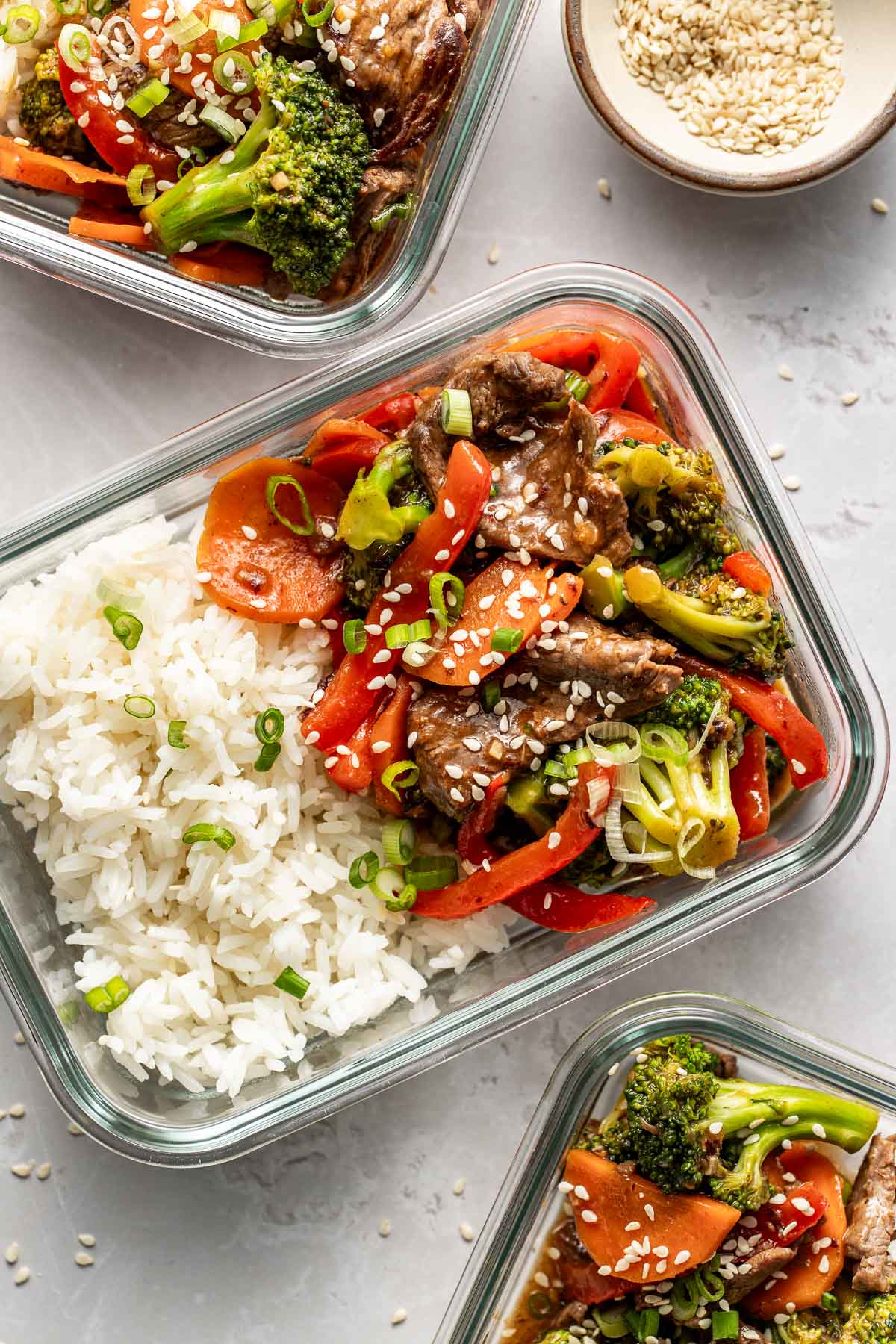 Overhead view of two glass meal prep containers filled with white rice and Steak Stir Fry