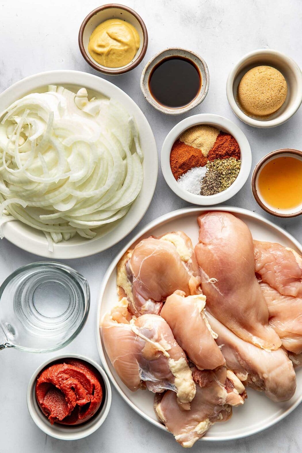 Overhead view of a variety of ingredients for BBQ Pulled Chicken in different sized bowls.