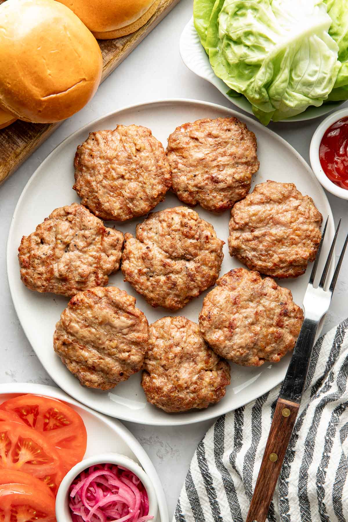 Overhead view of a platter filled with freshly grilled turkey burgers. 