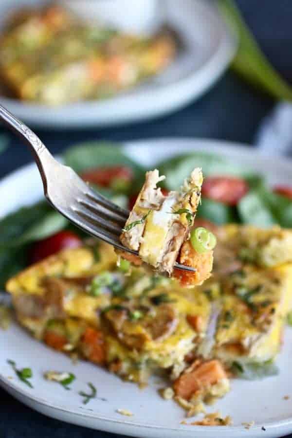 A bite of Sweet Potato Chicken Sausage Egg Bake on a fork lifted towards the camera