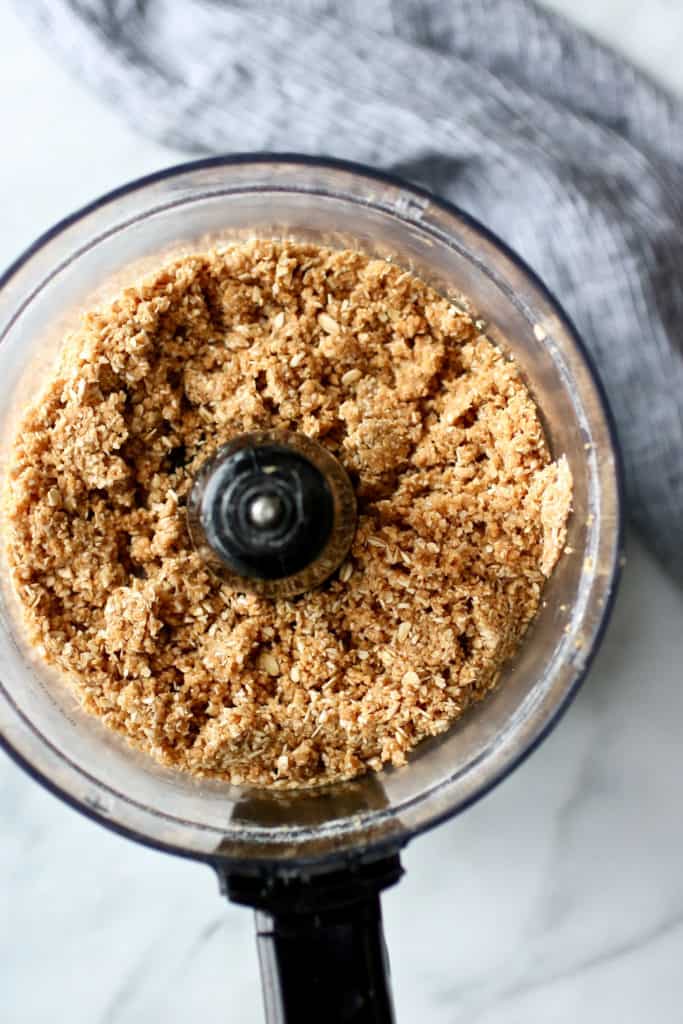 Processed peanut butter bite mixture in food processor. 
