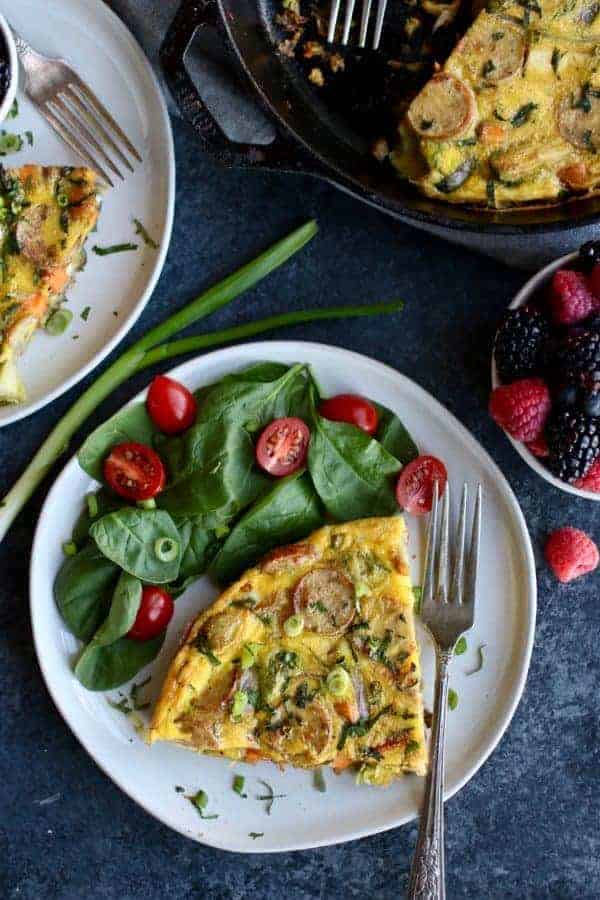 Overhead view of Sweet Potato Chicken Sausage Egg Bake with spinach and tomatoes on a white plate
