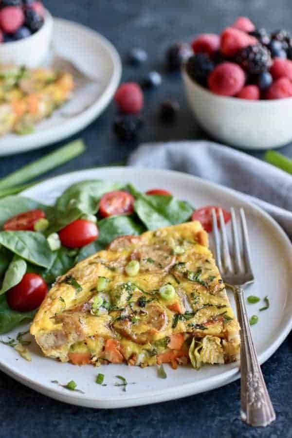 Sweet Potato Chicken Sausage Egg Bake on a white plate with spinach and grape tomatoes