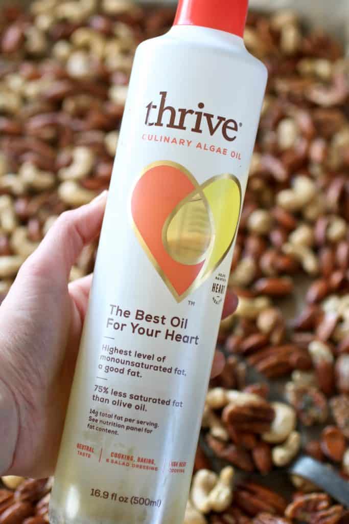 A hand holding a bottle of algae oil