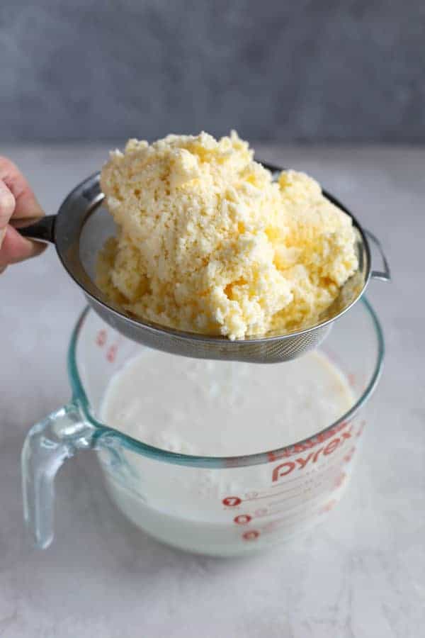 Homemade butter in a strainer. Buttermilk is being strained off.