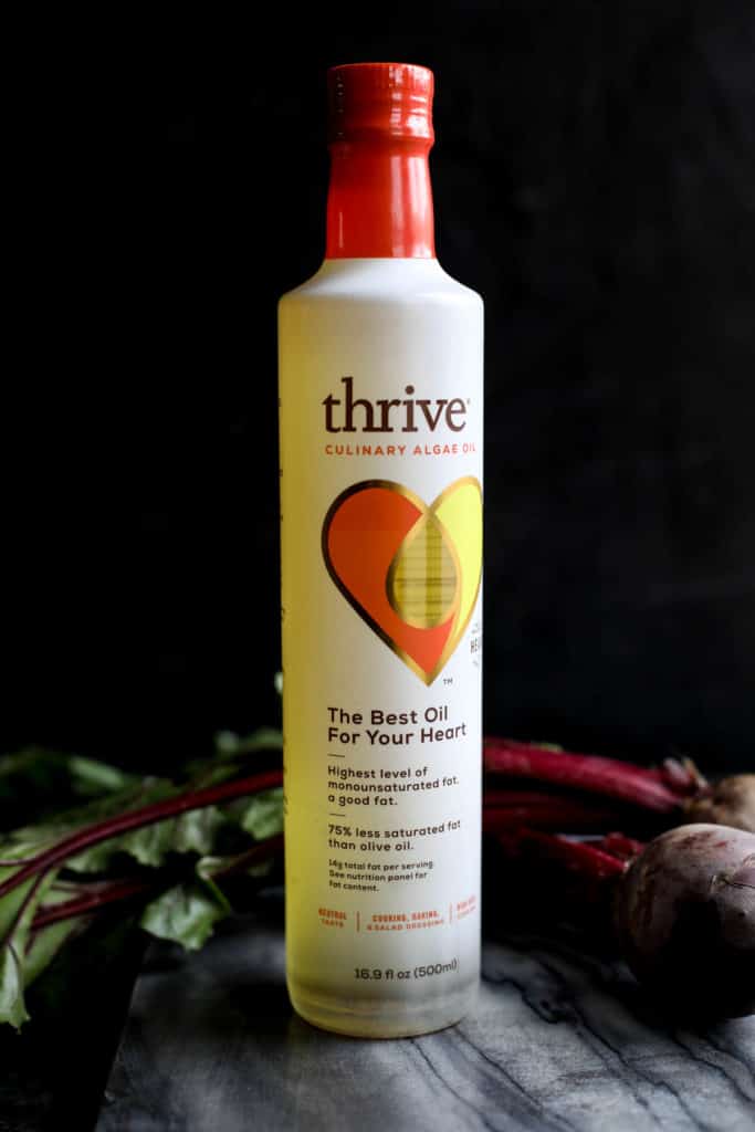 A bottle of algae oil on a black countertop