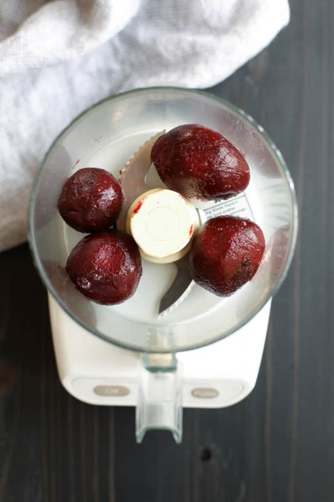 Overhead view of 4 beets in a food processor