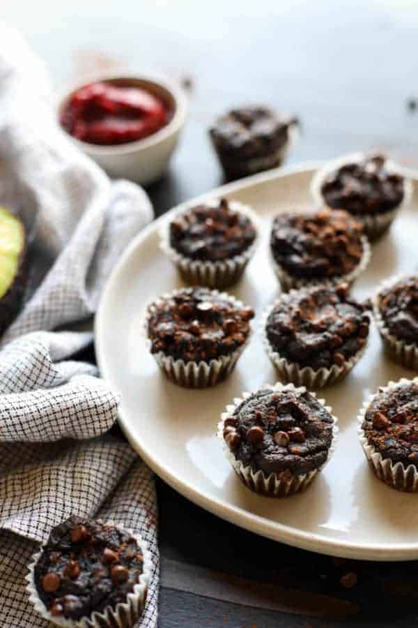White plate of Paleo Double Chocolate Beet Brownies (in mini muffin form) sitting on a table with a napkin next to the plate.